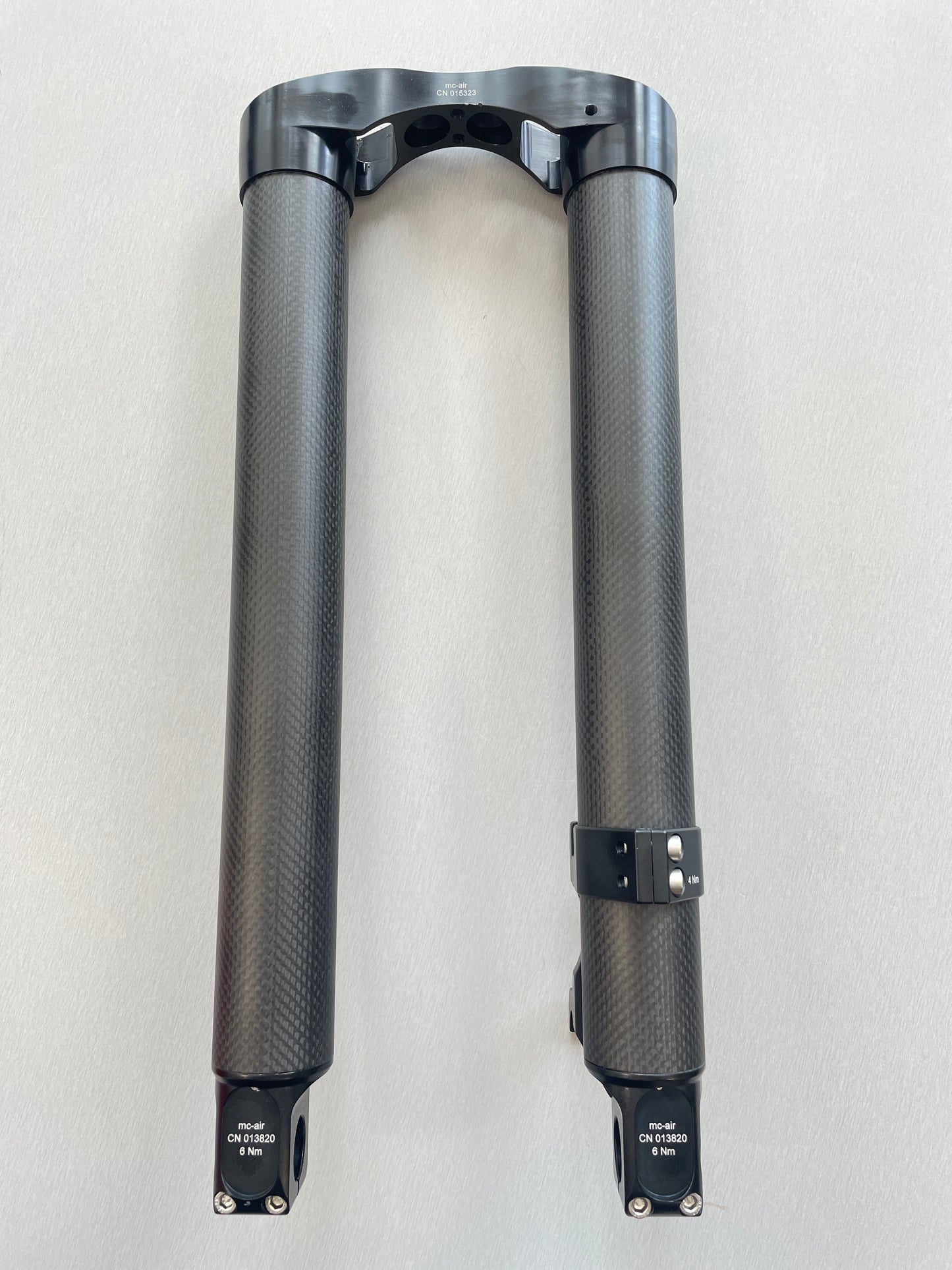 On a table lies the lower part of a Votec fork made of carbon. The two fork legs and the brake mount are clearly visible.